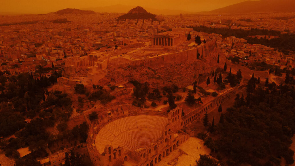 Inquietanti cieli arancioni incombono su Atene mentre una tempesta di polvere travolge la Grecia meridionale